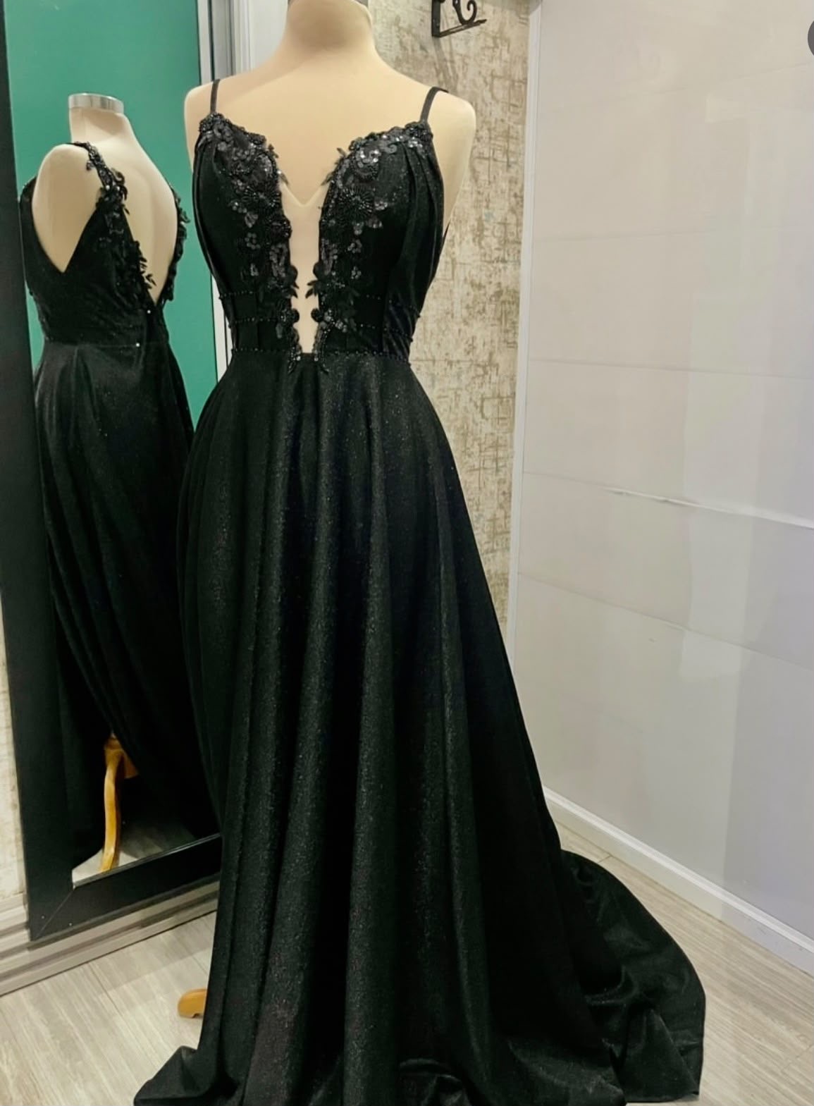 Vestido de gala negro, escote profunda y falda ancha con brillos