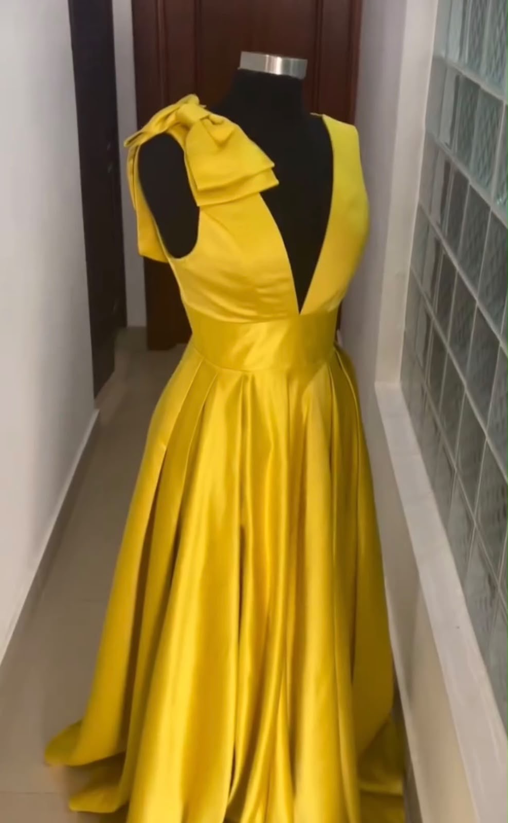 Vestido de gala amarillo satinado con moño en el hombro
